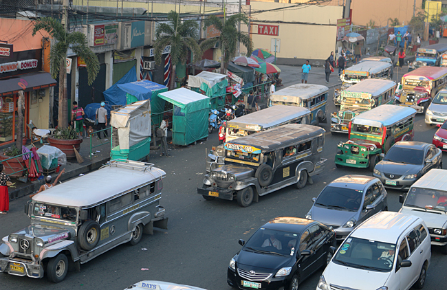 Jeepneys can tend to flood the streets of Manila, as their fares tend to be very inexpensive. Photograph ©2014 by Brian Cohen.